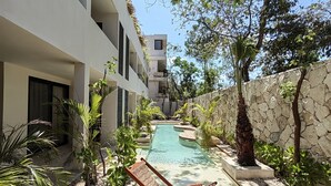A pool area with a wooden deck, lounge chairs, and potted plants. - ITZÁ ALDEA ZAMÁ - BOHO CHIC con Alberca (Tulum)
