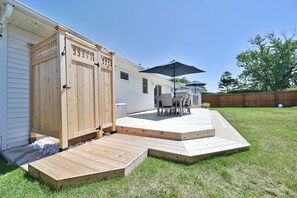 Enjoy an outdoor space with a covered patio, wooden deck, and comfortable seating area.