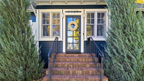 A house with a number 1025 on the front door, a brick staircase leading up to the entrance, and a wreath hanging on the door. - Vintage Modern near Downtown - Arcade Machine (Rapid City)