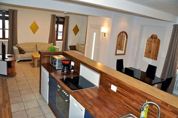 A compact living space with a kitchenette, a dining area, and a sofa.