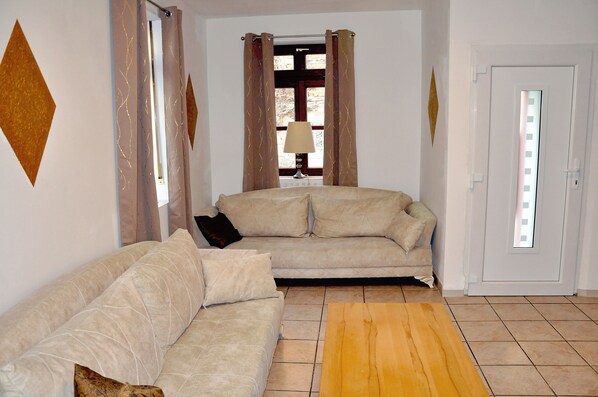 A living room with a beige sofa, a wooden coffee table, and a lamp.