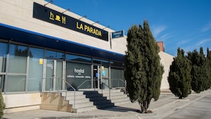 A modern building with a sign reading "LA PARADA" and "Hostal". - Hostal La Parada (Getafe)
