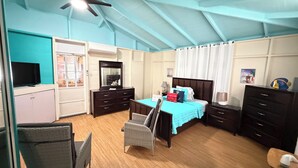 A bedroom with a bed, a television, a dresser, and a chair. - The Place at the Sea (Ponce)