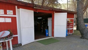 A red building with a white door and a signboard. - Camping Green Village Pin Tourist (Palagiano)