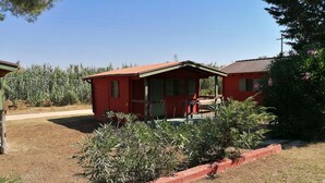 A red building with a porch and a bench. - Camping Green Village Pin Tourist (Palagiano)