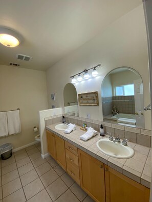 A bathroom with two sinks, a large mirror, and a shower area. - Seaside! Steps to sand & minutes to dunes! (Oceano)