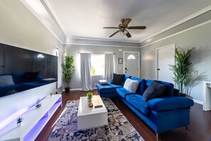 Relax in this stylish living room with a large flat-screen TV, plush sofa, and a cozy coffee table.