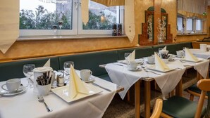 Un restaurante con mesas dispuestas para comer, que ofrece vistas del exterior a través de amplios ventanales.
