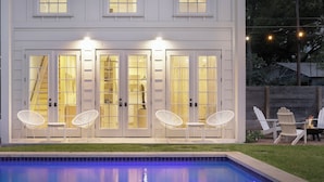 A two-story house with a swimming pool, white doors, and outdoor seating. -  #1 VRBO in Austin HEATED POOL, central to 6th and Rainey (Austin)