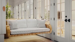 A room with a white sofa, large windows, and a ceiling fan. -  #1 VRBO in Austin HEATED POOL, central to 6th and Rainey (Austin)