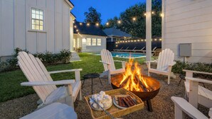 A backyard with a fire pit, outdoor seating, and a swimming pool. -  #1 VRBO in Austin HEATED POOL, central to 6th and Rainey (Austin)