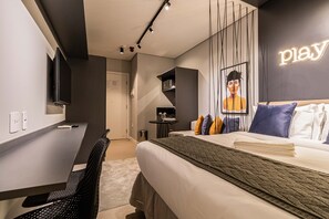 A modern hotel room with a bed, a desk, a chair, and a TV. - Charlie Houx Faria Lima (São Paulo)