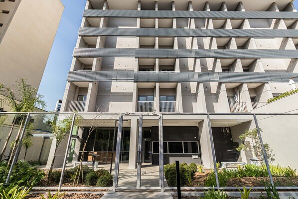 A multi-story building with a modern architectural design, featuring balconies and a gated entrance. - Charlie Houx Faria Lima (São Paulo)