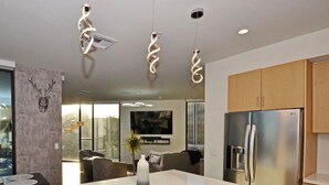 A modern kitchen with a central island, stainless steel appliances, and pendant lighting. - Luxury High Rise Flat - Free Underground Parking (Tucson)