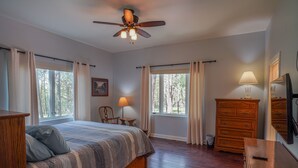 A bedroom with a bed, wooden dresser, and a ceiling fan. - AMAZING 4300 SQ FEET RETREAT ON  4.5 ACRES WITH AC!! SLEEPS 16 PETS WELCOME! (Pinetop-Lakeside)