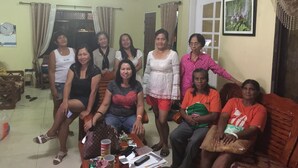 A group of people in a living room with a sofa, chairs, a coffee table with items, and a door in the background. - Gated community (Davao city)