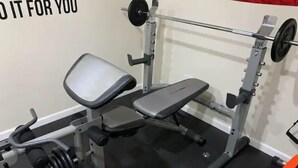 A weight bench with a barbell and weight plates, a wall-mounted mirror, and a red towel. - Private Suite · Patio · BBQ · GYM · Beach: 5 Miles (Largo)