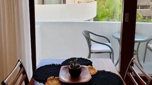 Una taula de menjador amb un suport per plats negre, un bol petit i un objecte decoratiu.
