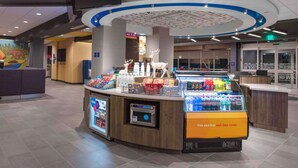 A self-service beverage station with refrigerated drinks, a microwave, and a cash register. - Tru By Hilton Manteca, Ca (Manteca)