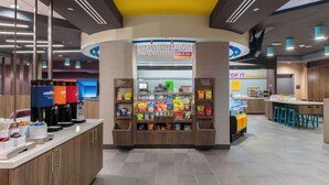 A self-service beverage station with multiple dispensers and a variety of snacks. - Tru By Hilton Manteca, Ca (Manteca)