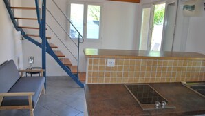 Eine Küche mit Fliesenrückwand, einer Holzbank und einer Treppe mit blauen Geländern.