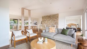 Relax in a spacious living area with a comfortable sofa, additional seating, and a functional coffee table.