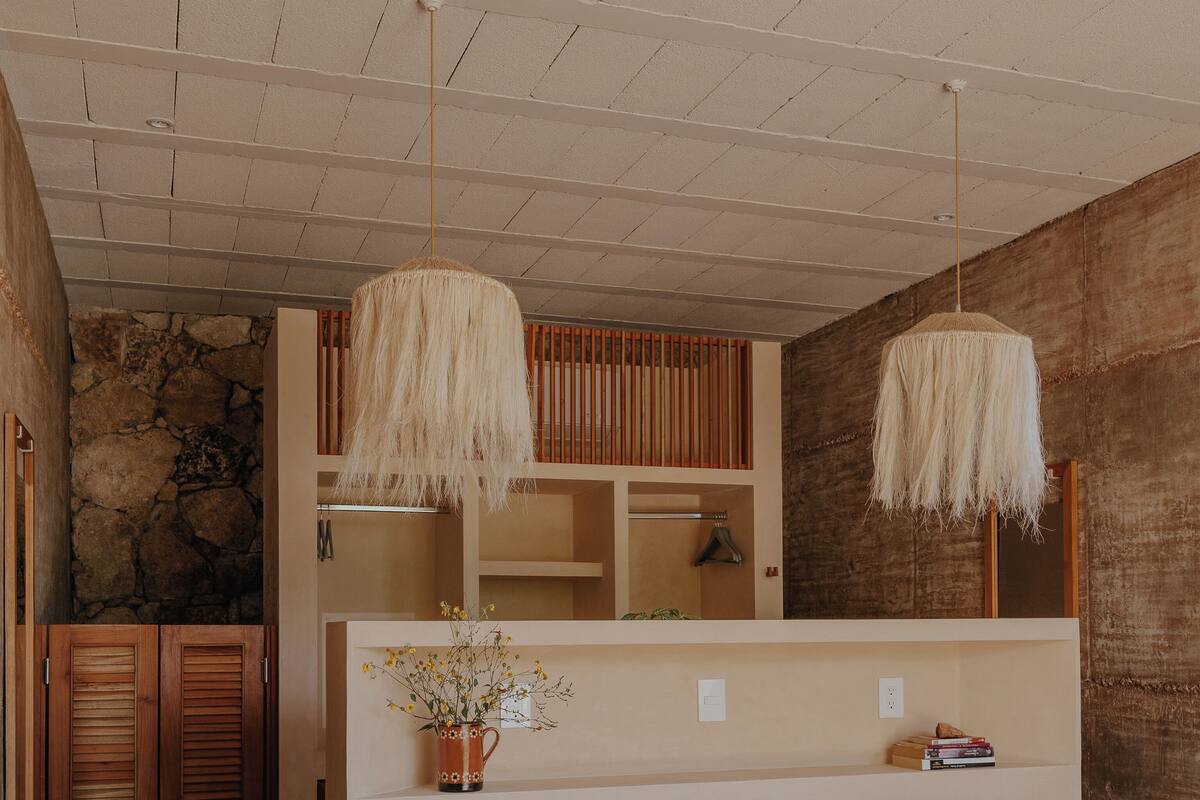Un dormitorio con cama, armario de madera y pared de piedra.