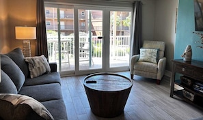 A living room with a sofa, armchair, and a round coffee table.