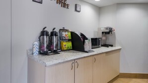 Una estación de café con una máquina de café, espumador de leche y molinillo.