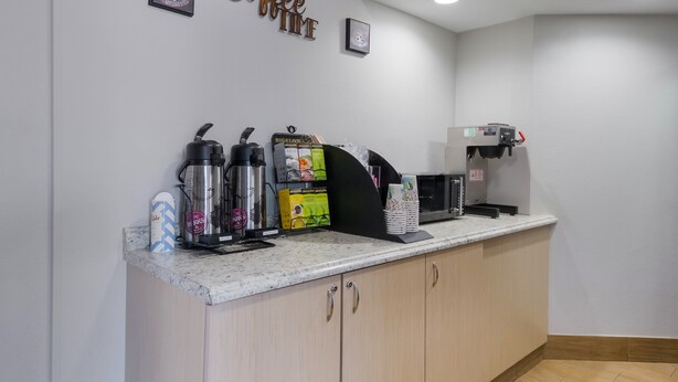 A coffee station with a coffee machine, a milk frother, and a coffee grinder.