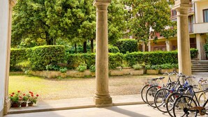Ein architektonischer Innenhof mit Säulen, einem zentralen Brunnen und einem Garten.