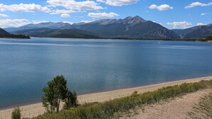 Un lac avec des montagnes en arrière-plan et un ciel dégagé.