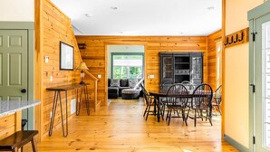 Ein Holzinterieur mit Essbereich, einer Couch und einer Küchenzeile.
