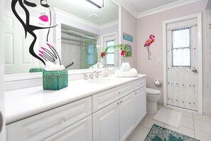 A bathroom with a white vanity, a mirror, a toilet, and a shower area. - Swimming pool, lake view, minutes to Naple's downtown and beach. (Naples)