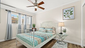 A bedroom with a bed, a ceiling fan, a window with curtains, a bedside table with a lamp, and a framed picture on the wall. - Bright&Cozy Getaway 10min to Downtown LA (Alhambra)