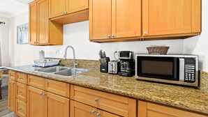 A kitchen with wooden cabinets, granite countertop, stainless steel sink, and a microwave. - Bright&Cozy Getaway 10min to Downtown LA (Alhambra)