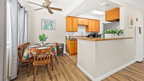 A modern kitchen with wooden cabinets, a central island, and a ceiling fan. - Bright&Cozy Getaway 10min to Downtown LA (Alhambra)