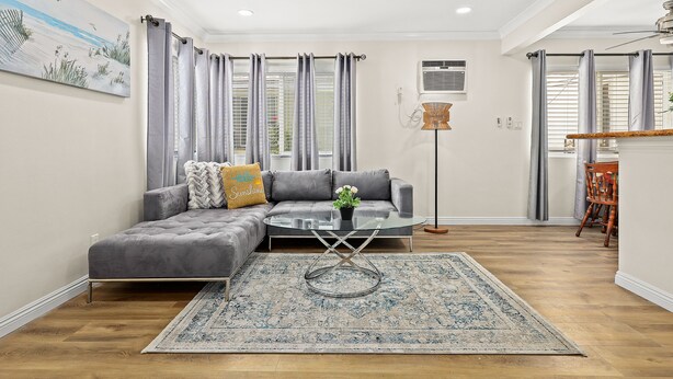 A modern living room with a grey sectional sofa, a glass coffee table, and a patterned rug. - Bright&Cozy Getaway 10min to Downtown LA (Alhambra)