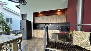 Una cocina moderna con una parrilla empotrada, armarios de madera y un comedor con mesa y sillas.