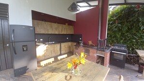 Une cuisine moderne avec des meubles en bois, un réfrigérateur noir et un four en briques.