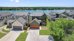 A residential area with houses, a lake, and a bridge. - Waterhouse at Lake LBJ Residence III 6 King Beds, Pool/Spa, Boat/PWC Lift, Slide (Kingsland)