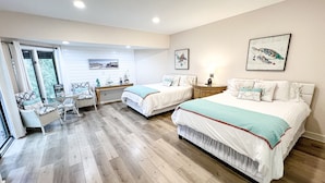 Un dormitorio con dos camas, un escritorio y una silla.