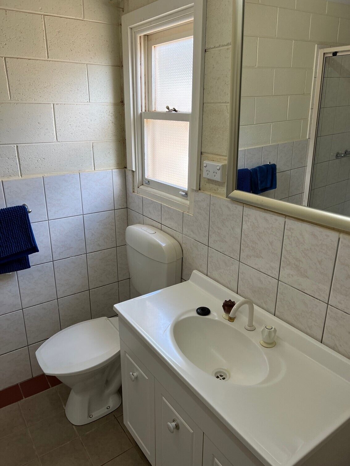 Un baño con inodoro, lavamanos y ventana.