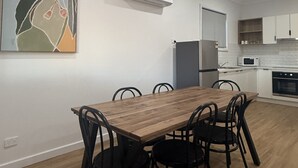 Una cocina moderna con armarios blancos, un microondas y un horno empotrado.