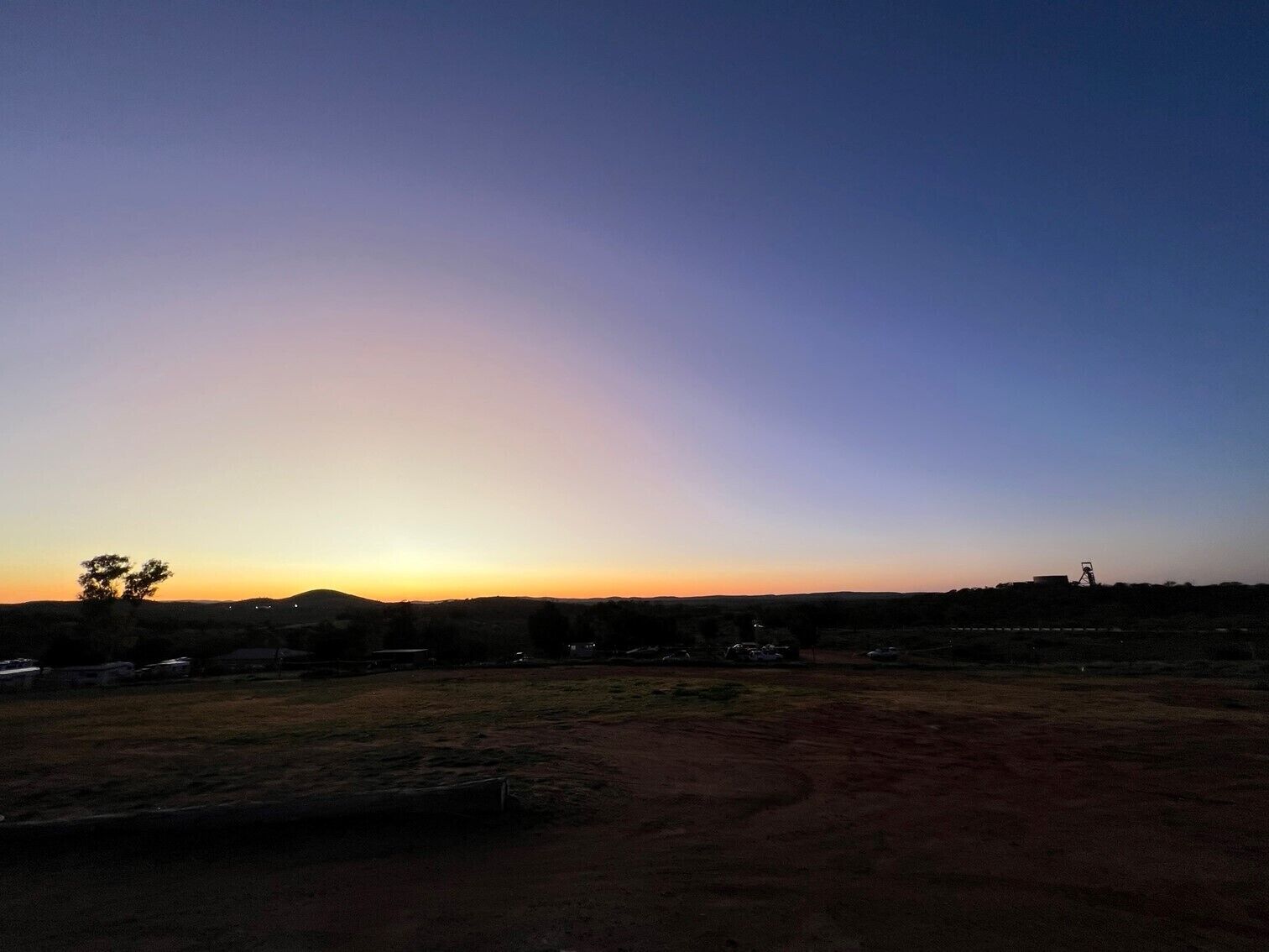 Un paysage plat, avec un ciel dégagé au coucher du soleil.
