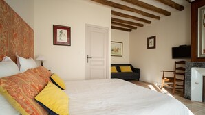 A bedroom with a large bed, a sofa, a television, and a door leading to another room. - La Bulle d'Or-House-Deluxe-Whirlpool bath-Garden view (Francueil)