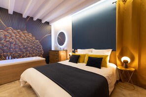 Un dormitorio moderno con una cama grande, una mesita de noche de madera, un espejo redondo y un diseño de pared original.