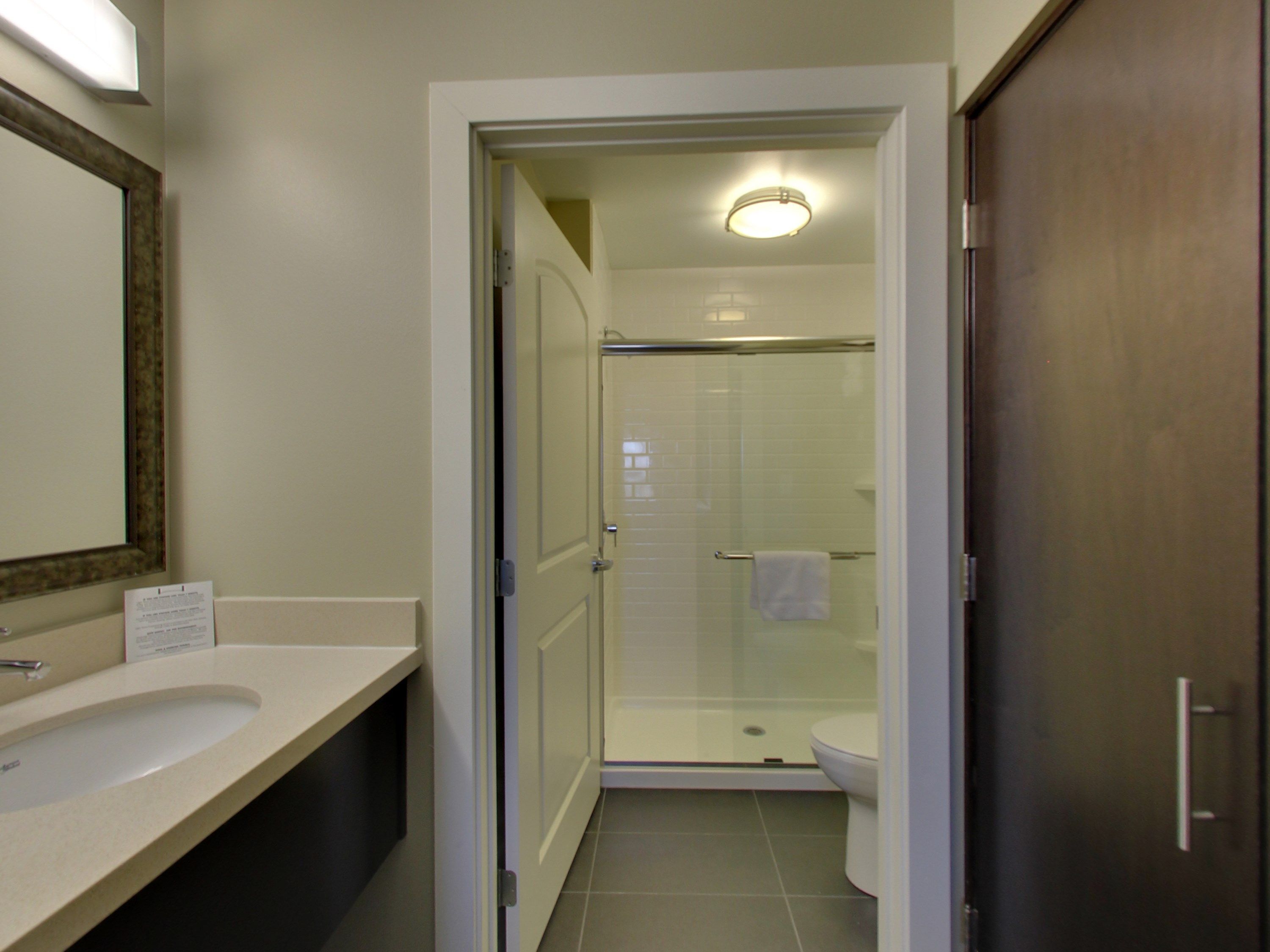 Un baño con lavamanos, inodoro y cabina de ducha de vidrio.