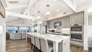 A spacious kitchen with a large island, modern appliances, and a view to the outside. - Happy Sol *9 bedroom*Oceanfront*Elevator*Pool (Nags Head)