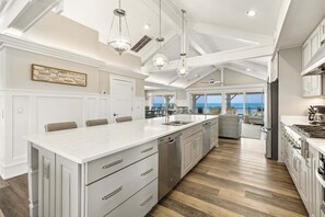 A spacious kitchen with a large island, modern appliances, and a view to the outside.